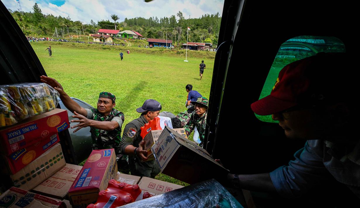 Distribusi logistik dilakukan melalui jalur udara dengan menggunakan helikopter. Tampak dalam foto, personel TNI AU menurunkan bantuan yang didistribusikan kepada warga di wilayah terdampak banjir di Kabupaten Bener Meriah, Provinsi Aceh, pada Kamis 4 Desember 2025. (CHAIDEER MAHYUDDIN/AFP)