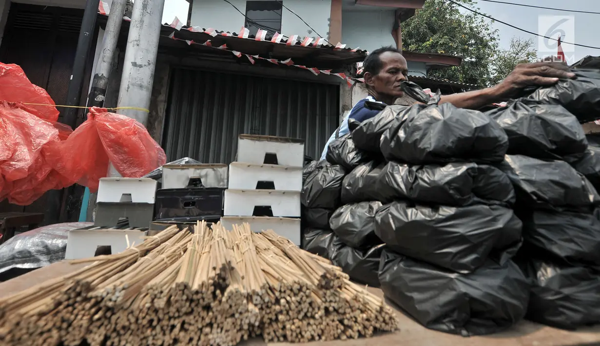 Penjual arang, tusuk sate, dan kotak pemanggang merapikan dagangannya di kawasan Manggarai, Jakarta, Rabu (22/8). Belasan penjual perlengkapan membuat sate menjamur saat Hari Raya Idul Adha 2018. (Merdeka.com/Iqbal Nugroho)