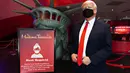 Sosok Donald Trump yang bermasker berdiri di dekat tanda bertuliskan Mask Required' saat Madame Tussauds New York dibuka kembali di New York City, Kamis (27/8/2020). Patung lilin Donald Trump dengan mengenakan masker akan menyambut pengunjung dipintu masuk museum. (Cindy Ord/Getty Images/AFP)