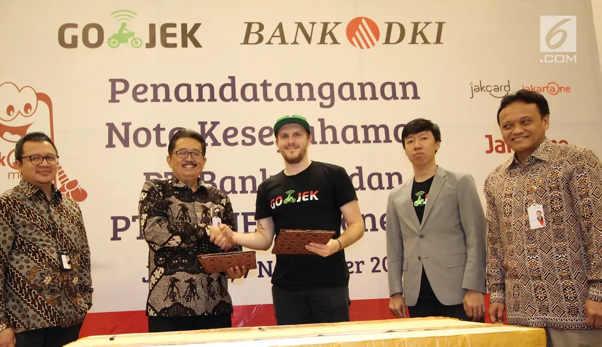 Direktur Bisnis Bank DKI,  Antonius Widodo Mulyono (kedua kiri) dan CMO Go-Jek,  Piotr Jakubowski (tengah) usai MoU antara Bank DKI dengan Gojek Indonesia, Selasa (7/11). (Liputan6.com/Pool/Budi)