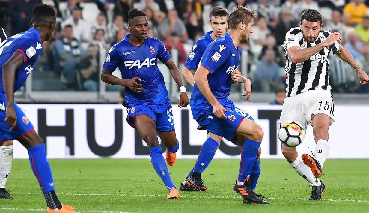 Pemain Juventus, Andrea Barzagli melakukan tembakan melewati adangan pemain Bologna pada lanjutan Serie A di Allianz Stadium, Turin, (5/5/2018). Juventus menang 3-1. (Alessandro Di Marco/ANSA via AP)