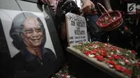 Keluarga dan kerabat menaburkan bunga di atas makam Yon Koeswoyo di TPU Tanah Kusir, Jakarta Selatan, Sabtu (6/1).   Yon Koeswoyo meninggal dunia pada usianya yang ke-77 tahun karena menderita sakit komplikasi. (Liputan6.com/Arya Manggala)