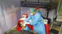 Salah seorang warga Kota Tangerang yang kembali dari kampung halaman di tes swab antigen oleh petugas medis. (Liputan6.com/Pramita Tristiawati)