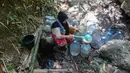 Warga  mengambil air untuk minum dan kebutuhan mck rumah  di sumber mata air Sumur Bendung, Gunung Batur, Kota Cilegon, Banten, Minggu, (15/7/2026). (KLY/Arie Basuki)