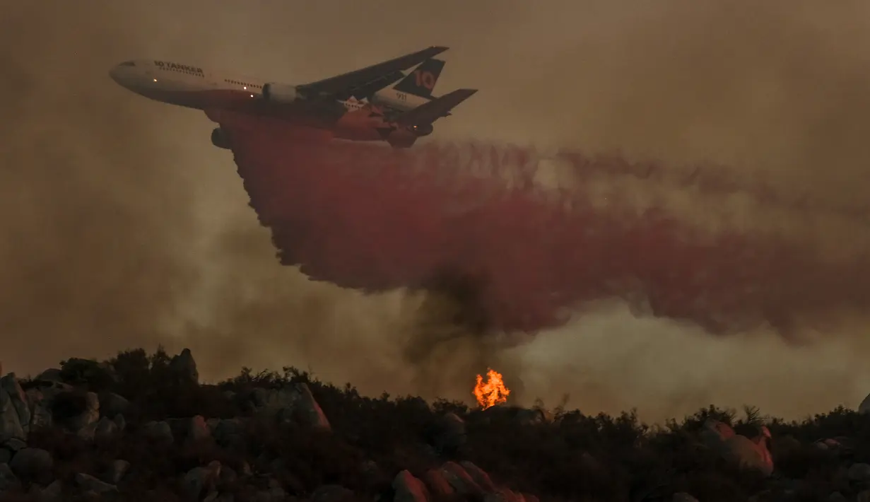 Sebuah tangki udara menjatuhkan bahan penghambat pada kebakaran hutan yang membakar di lereng bukit, Selasa (6/9/2022), dekat Hemet, California. Pada Selasa malam api telah membakar 4.500 hektar dan 5% terkandung, menurut tweet dari Cal Fire. (AP Photo/Ringo H.W. Chiu)