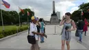 Joel Estrella menawarkan jasa foto kepada wisatawan di sebuah taman di Manila, (22/4). Estrella melihat penurunan pelanggan sejak munculnya ponsel kamera yang memotong penghasilannya ketika ia mulai sebagai fotografer muda. (AFP Photo/Ted Aljibe)