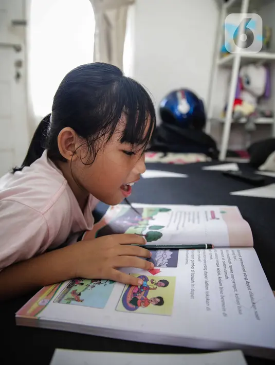 Seorang murid SD belajar di rumah bersama orang tuanya di kawasan Cinere, Jakarta, MInggu (5/4/2020). Hal itu sesuai dengan perpanjangan status tanggap darurat bencana pandemi Covid-19 bagi DKI hingga 19 April. (Liputan6.com/Faizal Fanani)