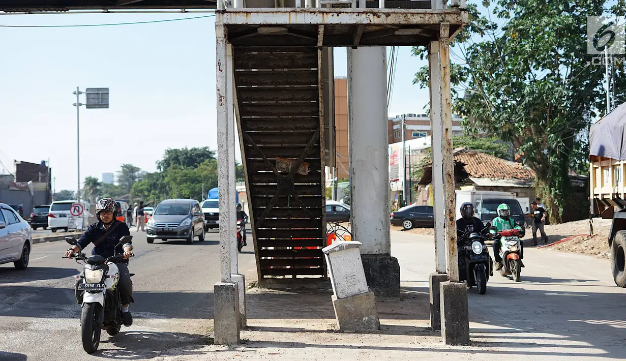 Pengenara sepeda motor melintas di samping tangga akses JPO di Jalan Antasari, Jakarta, Jumat (24/5/2019). Proyek pelebaran jalan yang tidak dibarengi dengan pemanjangan JPO menyebabkan akses tangga JPO tersebut berada di tengah jalan. (Liputan6.com/Immanuel Antonius)