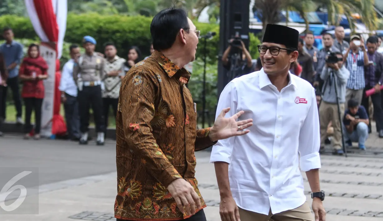 Gubernur DKI Jakarta Basuki Tjahaja Purnama (Ahok) jalan bersama dengan calon Wakil Gubernur DKI Jakarta Sandiaga Uno saat menghadiri deklarasi damai Pilgub DKI Jakarta putaran kedua di Jakarta, Senin (17/4). (Liputan6.com/Faizal Fanani)