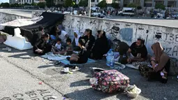 Puluhan warga berikut anak-anak dan perempuan panik melarikan diri dari serangan besar-besaran Israel. (JOSEPH EID/AFP)