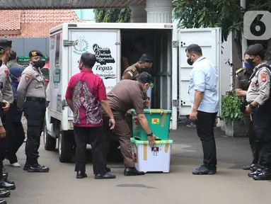 Petugas membawa barang bukti kasus pembunuhan berencana Brigadir J saat proses pelimpahan tahap dua kasus tersebut di Gedung Kejaksaan Agung, Jakarta, Rabu (5/10/2022). Penyidik Bareskrim Polri menyerahkan barang bukti beserta kesebelas tersangka kepada Kejaksaan Agung terkait kasus pembunuhan berencana Brigadir J dan obstruction of justice yang menjerat mantan Kadiv Propam Ferdy Sambo sebagai tersangka. (Liputan6.com/Herman Zakharia)