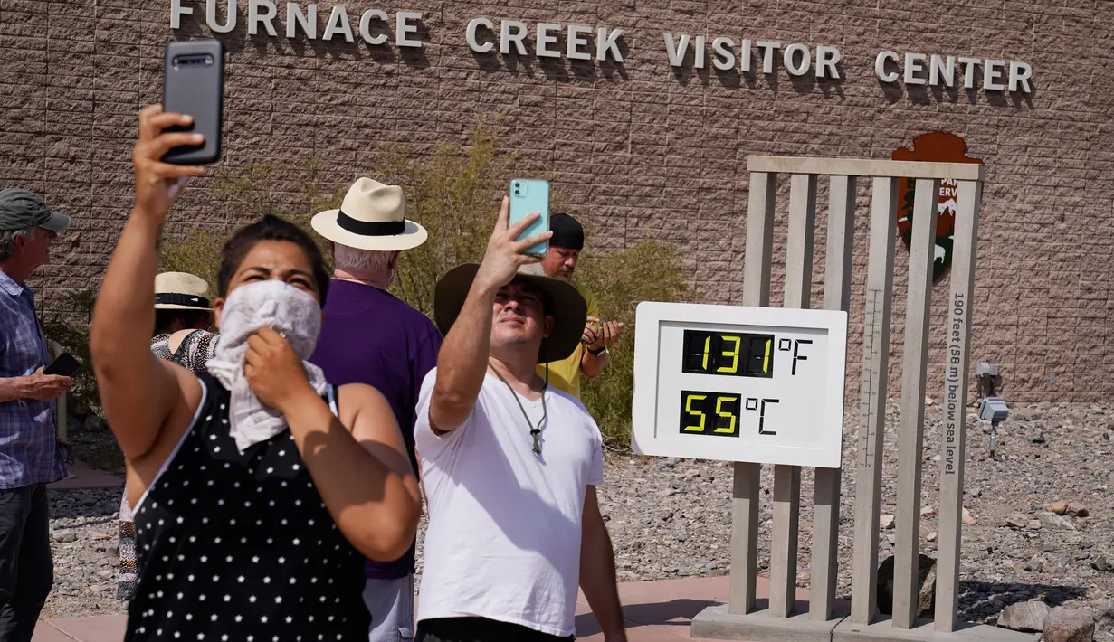Orang-orang berswafoto dengan termometer di Pos Pusat Pengunjung Furnace Creek, Taman Nasional Death Valley, California, AS, Senin (17/8/2020). Temperatur udara tertinggi di Dunia -- 54,4 derajat Celcius -- tercatat di Taman Nasional Death Valley pada Minggu 16 Agustus. (AP Photo/John Locher)