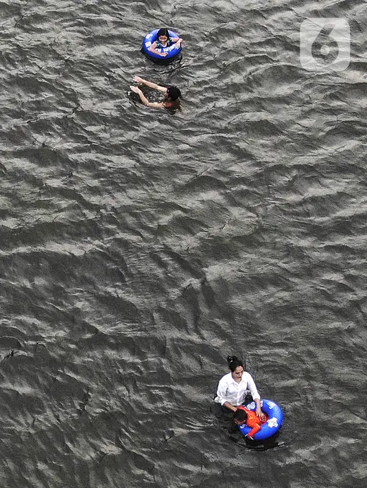 Foto udara menunjukkan pengunjung berenang di Pantai Karnaval Ancol, Jakarta, Jumat (14/5/2021). Ancol dibuka khusus bagi warga ber-KTP DKI Jakarta dan membatasi jumlah wisatawan dengan kapasitas 30 persen. (Liputan6.com/Johan Tallo)