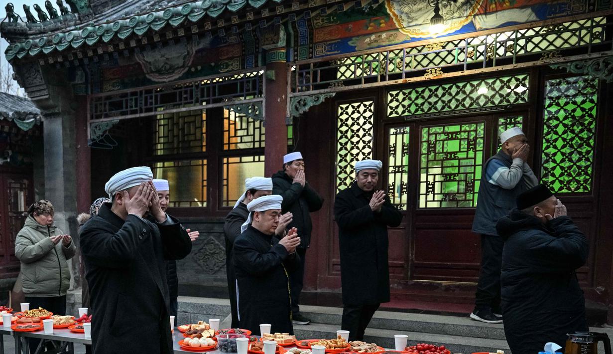 Sebagai kelompok Muslim terbesar di Tiongkok, Etnis Hui terintegrasi erat dengan budaya Tionghoa Han, menggunakan bahasa Mandarin, namun taat menjalankan syariat Islam. Tampak dalam foto, warga Muslim etnis Hui Tiongkok membaca doa sebelum berbuka puasa di sebuah masjid selama minggu terakhir bulan suci Ramadhan di Beijing pada 17 Maret 2026. (Adek BERRY/AFP)