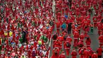 Orang-orang mengenakan kostum Sinterklas ambil bagian dalam Santa Claus Run di Madrid, Spanyol, Minggu (9/12). Ribuan orang berjalan dan berlari dalam perlombaan Santa tahunan melintasi jalan-jalan ibu kota Spanyol. (Gabriel BOUYS / AFP)