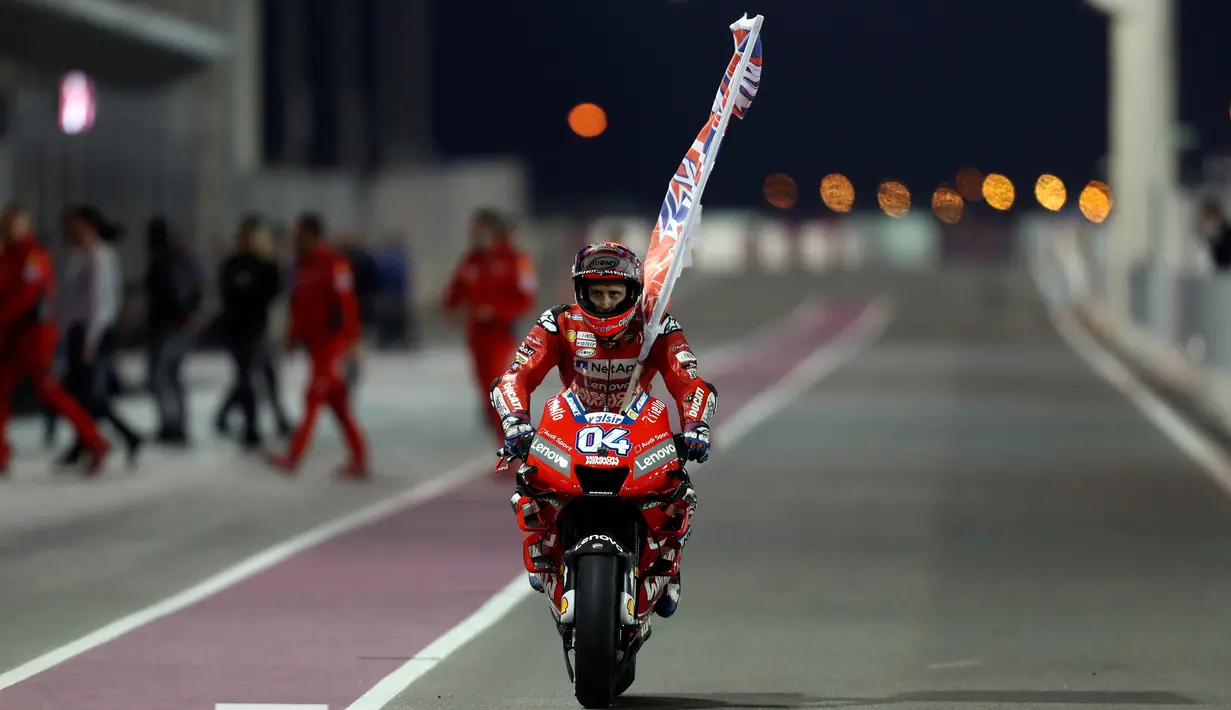 Pembalap Ducati, Andrea Dovizioso berselebrasi usai berhasil memenangkan seri pembuka MotoGP di Sirkuit Internasional Losail di Doha, Qatar (10/3). Ini kemenangan kedua beruntun Dovizioso di MotoGP Qatar. (AFP Photo/Karim Jaafar)