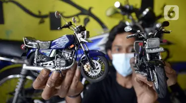 Perajin Wawang Kurniawan (38) menunjukkan pembuatan miniatur motor RX King di Kelurahan Serua, Ciputat, Tangerang Selatan, Sabtu (17/10/2020). Miniatur dari limbah korek api, pipa plastik, kabel, kaleng minuman, dan kawat itu dijual seharga Rp 400 - Rp 450 ribu per unit. (merdeka.com/Dwi Narwoko)