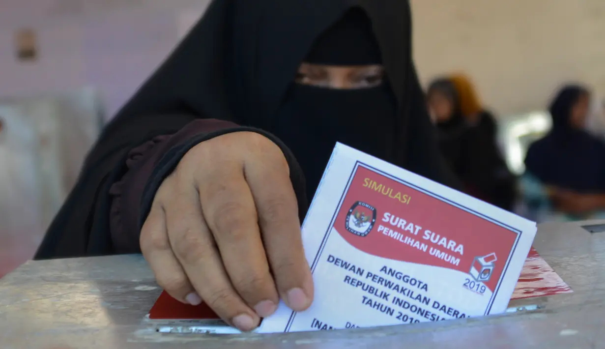 Seorang wanita memasukan kertas suaranya saat latihan pra-pemilihan di Banda Aceh, provinsi Aceh (6/4). Indonesia akan menyelenggarakan Pemilu serentak pada 17 April 2019. (AFP Photo/Chaideer Mahyudin)