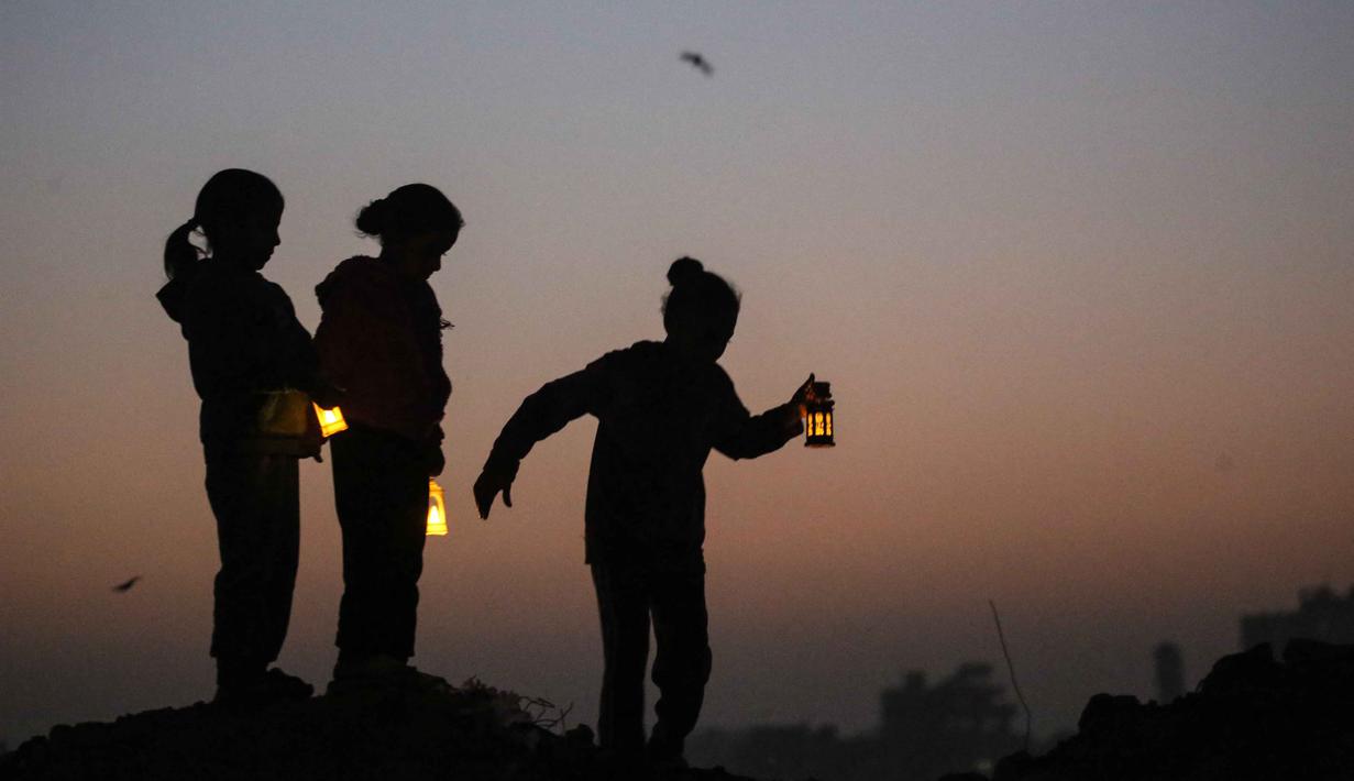 Persiapan Ramadan menjadi simbol ketahanan warga Palestina di Gaza. Lampion yang menerangi sela-sela tenda bukan sekadar hiasan, melainkan penanda harapan akan masa depan yang lebih baik. Tampak dalam foto, beberapa pengungsi muda Palestina bermain di reruntuhan bangunan yang hancur di kamp pengungsi Bureij di Jalur Gaza tengah pada 15 Februari 2026. (Eyad Baba/AFP)