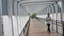 Pejalan kaki melintas di jembatan penyeberangan orang (JPO) Bundaran Senayan, Jakarta, Senin (21/1). Instalasi lampu akan menambah keindahan JPO di malam hari. (Liputan6.com/Faizal Fanani)