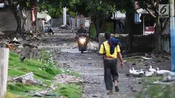 Pengendara motor melintas di dusun Regahan Lada, Pulau Sebesi, Lampung, Senin (31/12). Banyak warga dusun ini yang bertahan dan enggan meninggalkan rumahnya pascatsunami Selat Sunda pada 22 Desember lalu. (Liputan6.com/Herman Zakharia)