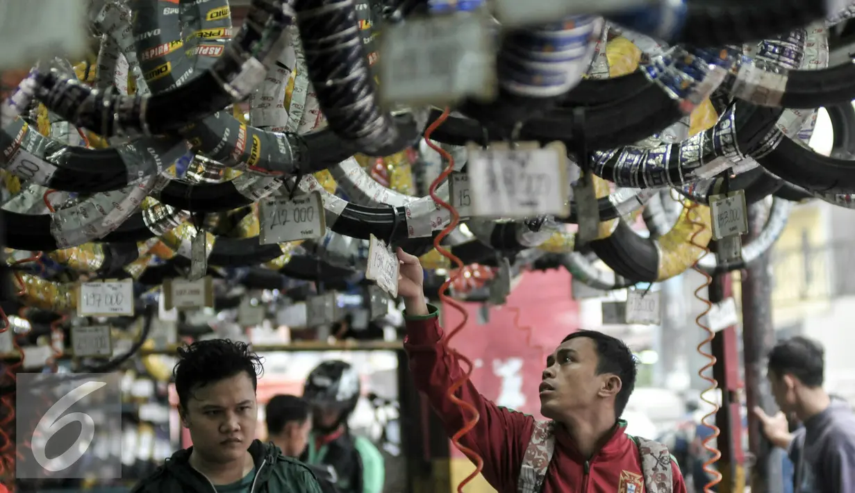Pelanggan jasa servis motor tengah melihat aksesoris kendaraan di bengkel di kawasan Pasar Minggu, Jakarta, Kamis (30/6). Jelang Lebaran, bengkel motor ramai dikunjungi pemudik motor. (Liputan6.com/Yoppy Renato)