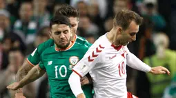 Pemain Denmark, Christian Eriksen dan pemain Republik Irlandia, Robbie Brady berebut bola pada partai kedua play-off zona Eropa di Stadion Aviva, Rabu (15/11). Denmark melaju ke putaran final Piala Dunia 2018 usai menang 5-1. (AP/Peter Morrison)