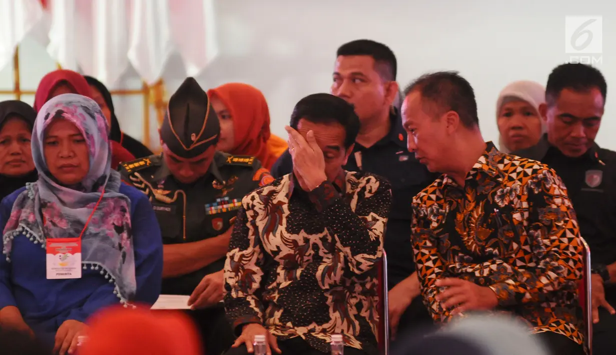 Presiden Joko Widodo berbincang dengan Mensos ‎Agus Gumiwang Kartasasmita saat menyalurkan bansos Program Keluarga Harapan (PKH) dan Bantuan Pangan Non Tunai (BPNT) kepada seribu warga Depok, Jawa Barat, Selasa (12/2). (Liputan6.com/Herman Zakharia)