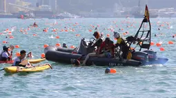 Petugas menyelamatkan perenang yang kelelahan ketika lomba renang lintas pelabuhan berjarak 1.500 meter di Hong Kong, Minggu (16/10). Sejumlah peserta lomba renang tahunan Lintas Pelabuhan Hong Kong mengalami kelelahan dan tenggelam. (REUTERS/APPLE DAILY)