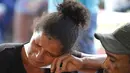 Seorang wanita menangis ketika dia menunggu di luar kantor koroner di Altamira, Brasil (30/7/2019). Kerabat narapidana yang terbunuh dalam kerusuhan penjara di Brasil utara berkumpul di kantor koroner melihat rekannya yang dicintainya tewas. (AP Photo/Raimundo Pacco)