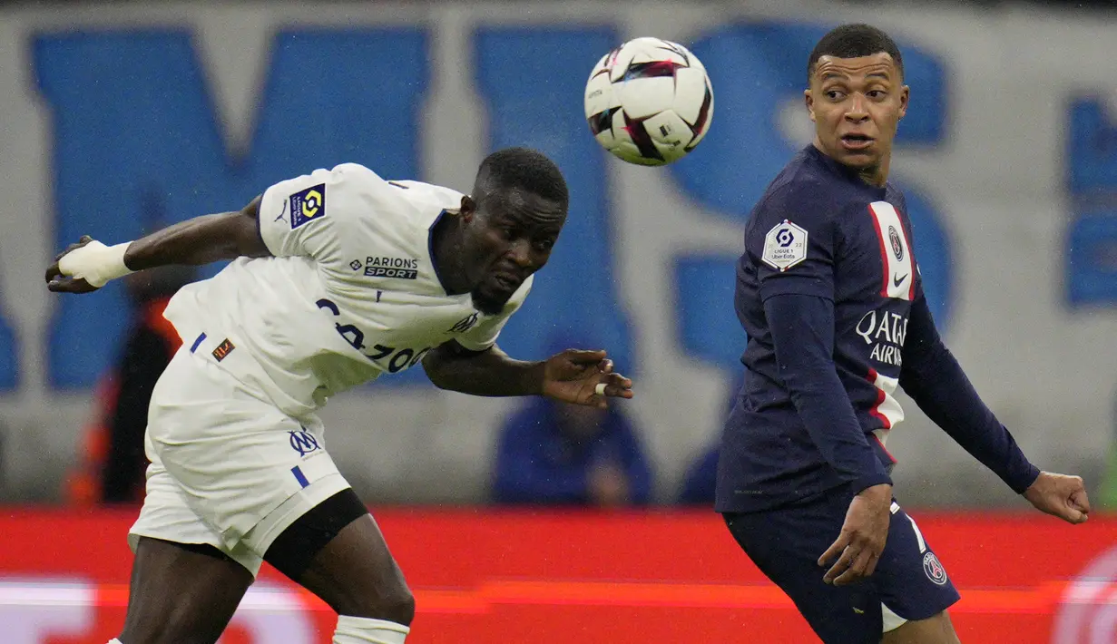 Bek Marseille  Eric Bailly berebut bola dengan penyerang Paris Saint-Germain (PSG) Kylian Mbappe dalam laga pekan ke-25 Liga Prancis 2022-2023, di Stadion Velodrome pada Senin (27/2/2023) dini hari WIB. Bertandang ke Orange Velodrome, laga ini krusial bagi PSG yang bermasalah dengan konsistensi dalam beberapa bulan terakhir. (AP Photo/Daniel Cole)