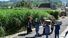 Warga membawa makanan menuju makam Desa Selo, Kabupaten Boyolali, Kamis (3/5). Tradisi ini Sebagai perayaan menyambut datangnya bulan ramadan, kemudian dilanjutkan makan bersama di pertigaan jalan desa. (Liputan6.com/Gholib)