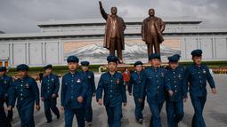 Anggota Liga Pemuda Korea Utara pergi setelah memberi penghormatan kepada patung-patung pemimpin Korea Utara Kim Il Sung dan Kim Jong Il di Pyongyang (15/4). (AFP Photo/Ed Jones)