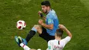 Penyerang Uruguay, Luis Suarez berebut bola dengan bek Portugal Raphael Guerreiro saat bertanding pada babak 16 besar Piala Dunia 2018 di Stadion Fisht, Sochi, Rusia (30/6). Uruguay menang tipis atas Portugal 2-1. (AP Photo/Darko Vojinovic)