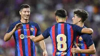 Gelandang Barcelona, Pedri (tengah), berselebrasi dengan Robert Lewandowski (kiri) dan  Gavi pada pertandingan uji coba Joan Gamper Trophy, melawan Club Universidad Nacional Pumas di Camp Nou, Senin (8/8/2022) dini hari WIB. (Pau Barrena/AFP)