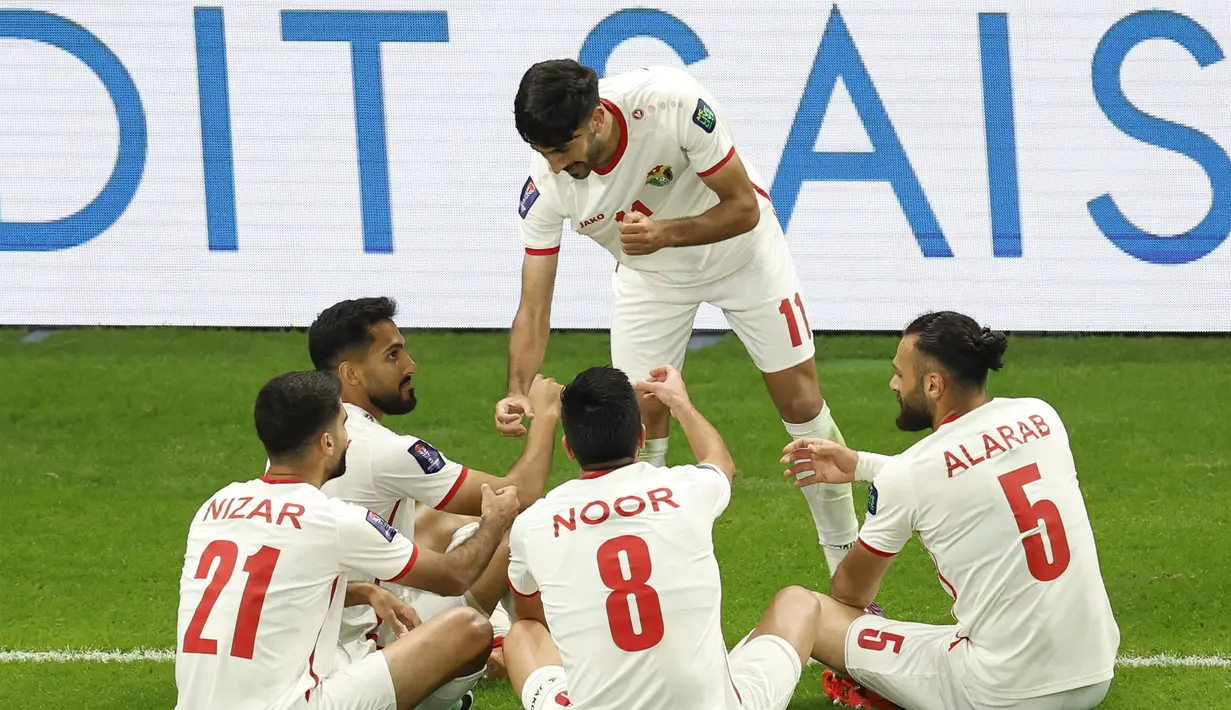 Pemain Yordania, Yazan Al-Naimat (tengah) melakukan selebrasi bersama rekan-rekannya setelah mencetak gol pertama timnya ke gawang Korea Selatan pada laga semifnial Piala Asia 2023 di Ahmad Bin Ali Stadium, Doha, Qatar, Selasa (06/02/2024). (AFP/Karim Jaafar)