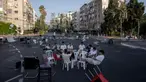 Sejumlah pemuda duduk bersama di persimpangan jalan bebas kendaraan saat perayaan Hari Raya Yom Kippur di Ramat Gan, Israel, Senin (25/9/2023). Banyak warga yang menggunakan sepeda ke jalan karena tidak ada lalu lintas yang diizinkan di jalan tersebut. (AP Photo/Oded Balilty)