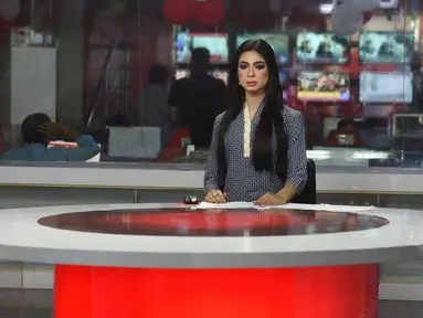 Pembawa berita transgender pertama di Pakistan,  Marvia Malik (21) membacakan berita untuk saluran televisi Kohenoor di Lahore, Selasa (27/3). Malik tampil perdana di televisi pada 23 Maret lalu dan langsung menjadi viral di media sosial. (ARIF ALI/AFP)