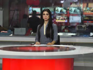 Pembawa berita transgender pertama di Pakistan,  Marvia Malik (21) membacakan berita untuk saluran televisi Kohenoor di Lahore, Selasa (27/3). Malik tampil perdana di televisi pada 23 Maret lalu dan langsung menjadi viral di media sosial. (ARIF ALI/AFP)
