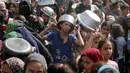 Seorang anak laki-laki Palestina yang sedang menunggu dengan pancinya untuk menerima seporsi makanan, di sebuah tempat penampungan yang telah dihuni banyak keluarga, di Nuseirat, pusat Jalur Gaza, pada 2 November 2025. Di sisi lain, PBB terus menyalurkan bantuan kemanusiaan di seluruh Gaza meski wilayah tersebut beberapa kembali diguncang serangan udara Israel. (EYAD BABA/AFP)