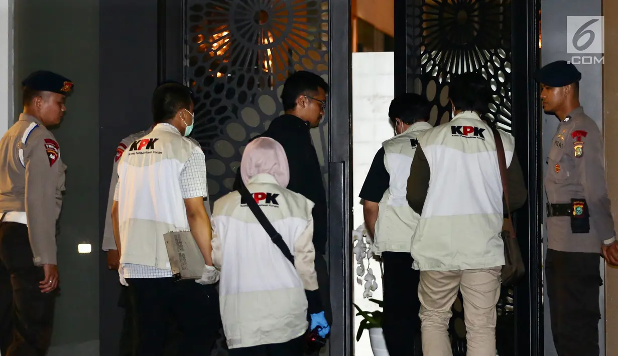 Sejumlah penyidik kenakan rompi KPK masuk ke dalam rumah tersangka Ketua DPR RI Setya Novanto dengan pengawalan ketat dari aparat kepolisian Brimob di Jalan Wijaya 13 No 19, Jakarta Selatan, Kamis (16/11). (Liputan6.com/Johan Tallo)