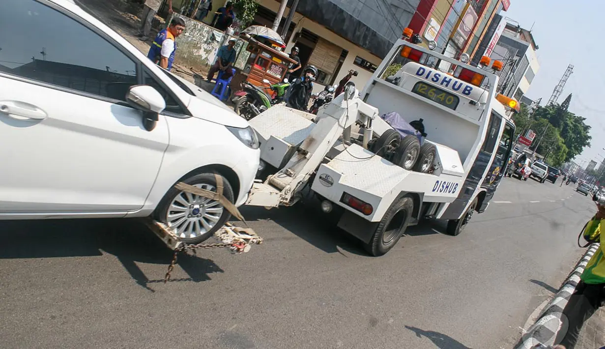 Sebuah mobil berwarna putih diangkut petugas Dishub di kawasan Fatmawati, Jakarta, Selasa (23/9/2014) (Liputan6.com/Faizal Fanani)