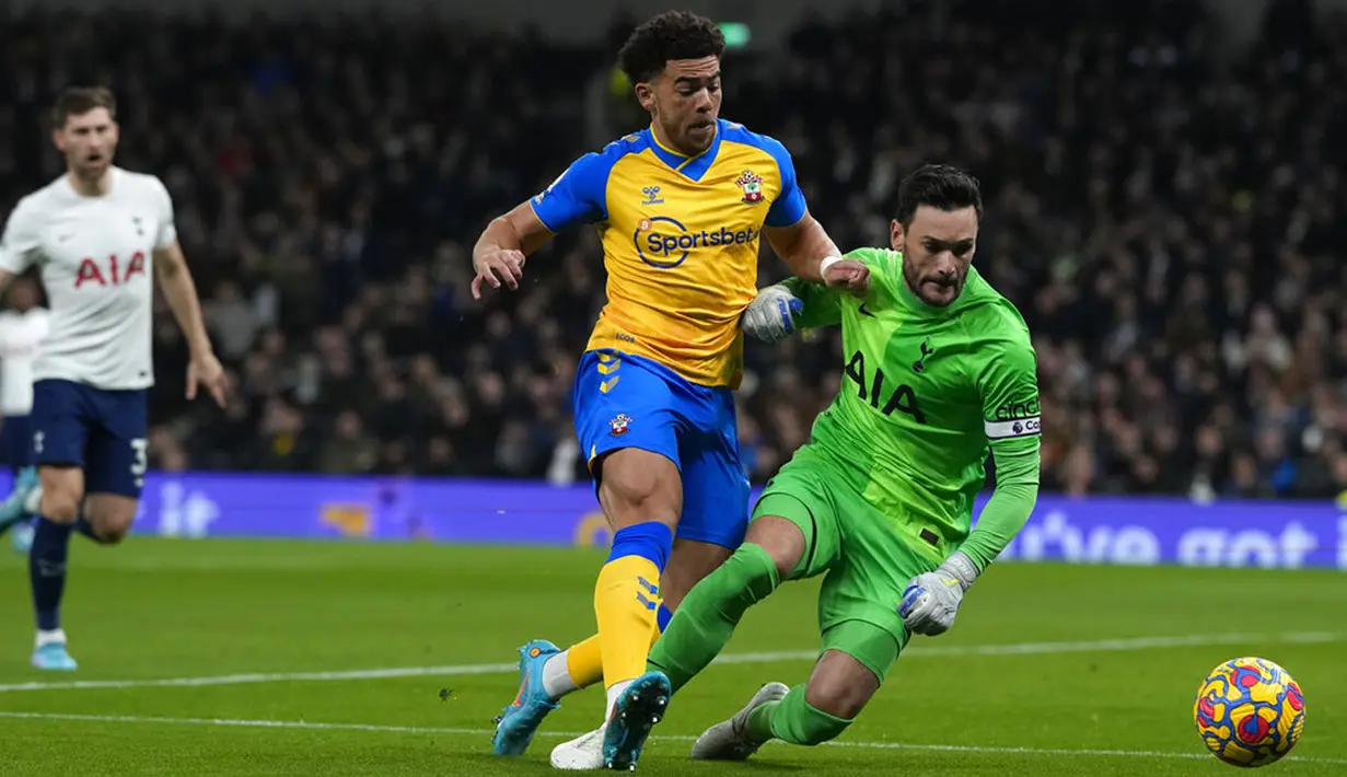 Penjaga gawang Tottenham Hotspur Hugo Lloris (kanan) berebut bola dengan pemain Southampton Che Adams pada pertandingan sepak bola Liga Inggris di Tottenham Hotspur Stadium, London, Inggris, 9 Februari 2022. Tottenham Hotspur kalah 2-3. (AP Photo/Alastair Grant)