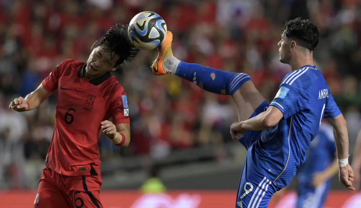 Pemain Timnas Korea Selatan U-20, Park Hyun-bin (kiri), berebut bola dengan pemain Italia U-20, Giuseppe Ambrosino, dalam pertandingan semifinal Piala Dunia U-20 2023 yang digelar di Estadio Unico Diego Maradona, La Plata, Jumat (9/6/2023) pagi WIB. (AFP/Juan Mabromata)