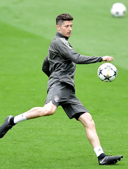 Penyerang Bayern Munchen, Robert Lewandowski menendang bola saat latihan di Stadion Santiago Bernabeu di Madrid (30/4). Pada leg pertama Munchen takluk atas Madrid 2-1 di Allianz Arena, Jerman.  (AFP Photo/Javier Soriano)