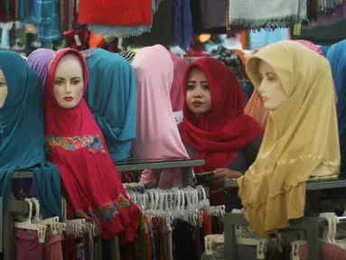 Seorang paramuniaga mengawasi model jilbab yang di jual di pasar Beringharjo, Yogyakarta, Rabu, (8/6/2016). Saat bulan ramadan, penjualan pakaian muslim mengalami peningkatan. (Liputan6.com/Boy Harjanto)