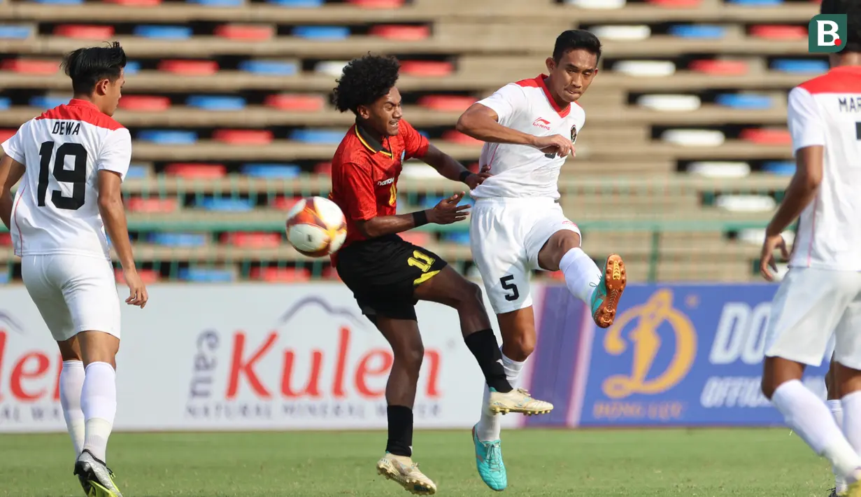 <p>Pemain Timnas Indonesia U-22,&nbsp;Rizky Ridho (kanan),&nbsp;menendang bola dibayangi pemain Timor Leste,&nbsp;Zenevio Morientes Gostavo Conceicao Mota pada pertandingan ketiga Grup A SEA Games 2023 yang berlangsung di Olympic Stadium, Phnom Penh, Kamboja, Minggu (7/5/2023). (Bola.com/Abdul Aziz)</p>