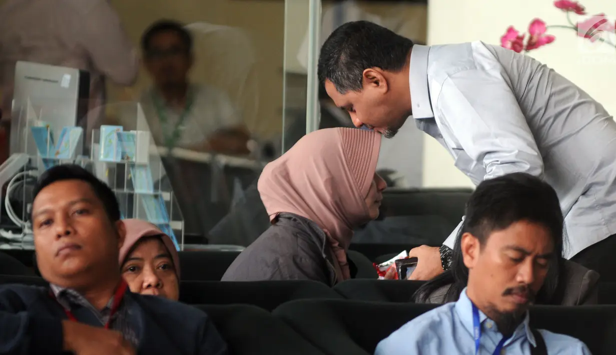 Suami anggota DPRD sekaligus cawalkot Malang 2018 Ya'qud Ananda Gudban, Hanif Thalib mencium sang istri jelang pemeriksaan di Gedung KPK, Jakarta, Selasa (27/3). Nanda diperiksa sebagai tersangka dugaan suap. (Merdeka.com/Dwi Narwoko)