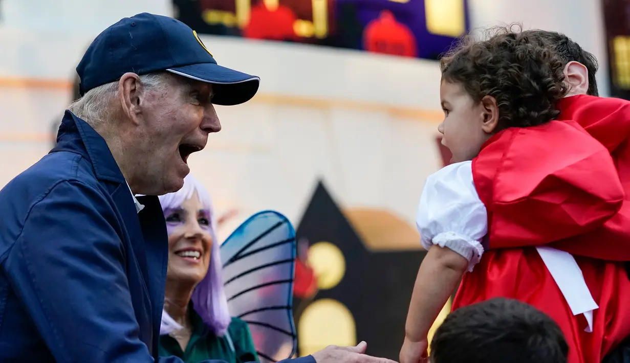 Presiden Amerika Serikat Joe Biden dan Ibu Negara Jill Biden memberikan suguhan kepada anak-anak saat perayaan Halloween di South Lawn Gedung Putih, Washington, Amerika Serikat, 31 Oktober 2022. Presiden dan Ibu Negara menjamu anak-anak petugas pemadam kebakaran, perawat, polisi, dan anggota Garda Nasional di Gedung Putih untuk melakukan trik-or-treat. (AP Photo/Alex Brandon)