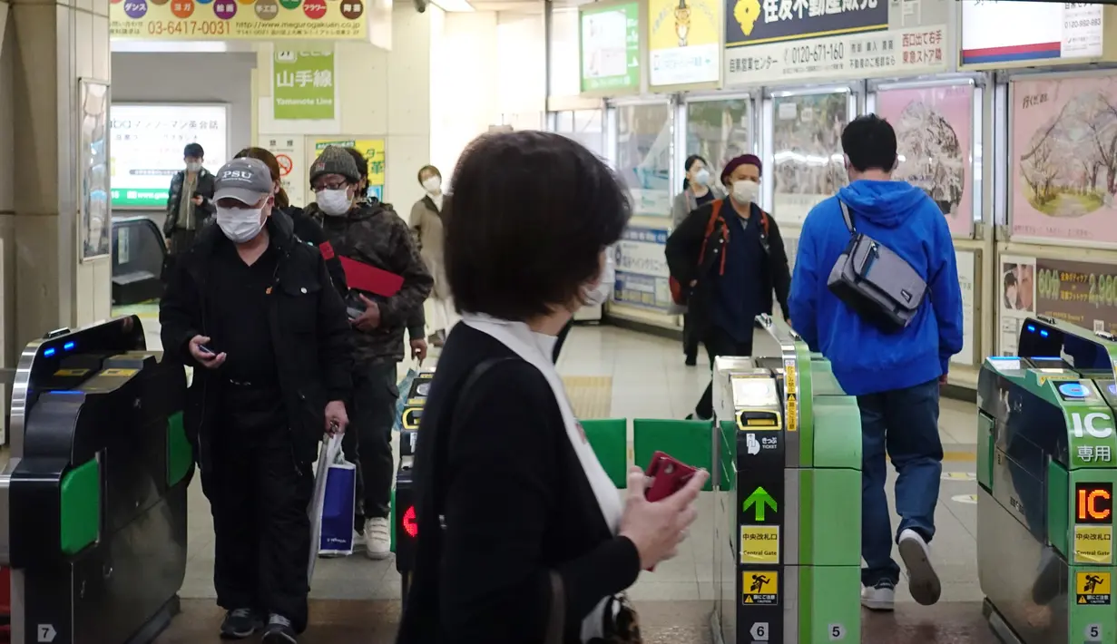 Sejumlah warga melewati gerbang tiket di Stasiun Meguro, Tokyo, Jepang (8/4/2020). Tidak seperti biasanya, kota Tokyo tampak sepi dengan banyak toko tutup dan hanya sedikit orang berada di jalanan pada (8/4), hari pertama setelah keadaan darurat diumumkan untuk membendung COVID-19. (Xinhua/Du Xiaoyi